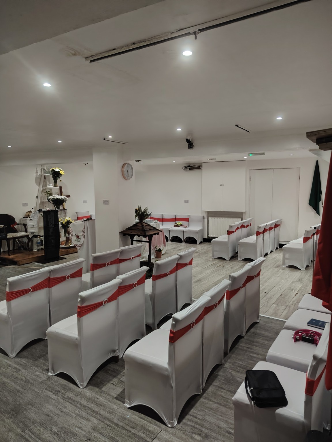 Basement hall with rows of white chairs and red sashes